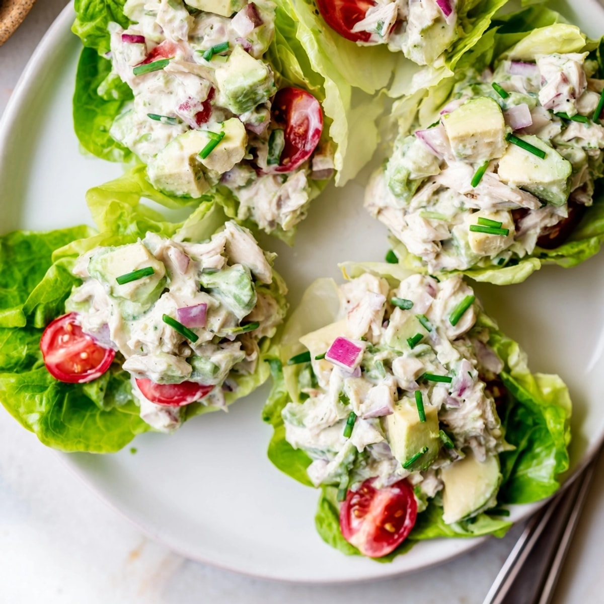 Close-up of avocado ranch chicken salad cups; creamy, savory chicken salad nestled in lettuce.