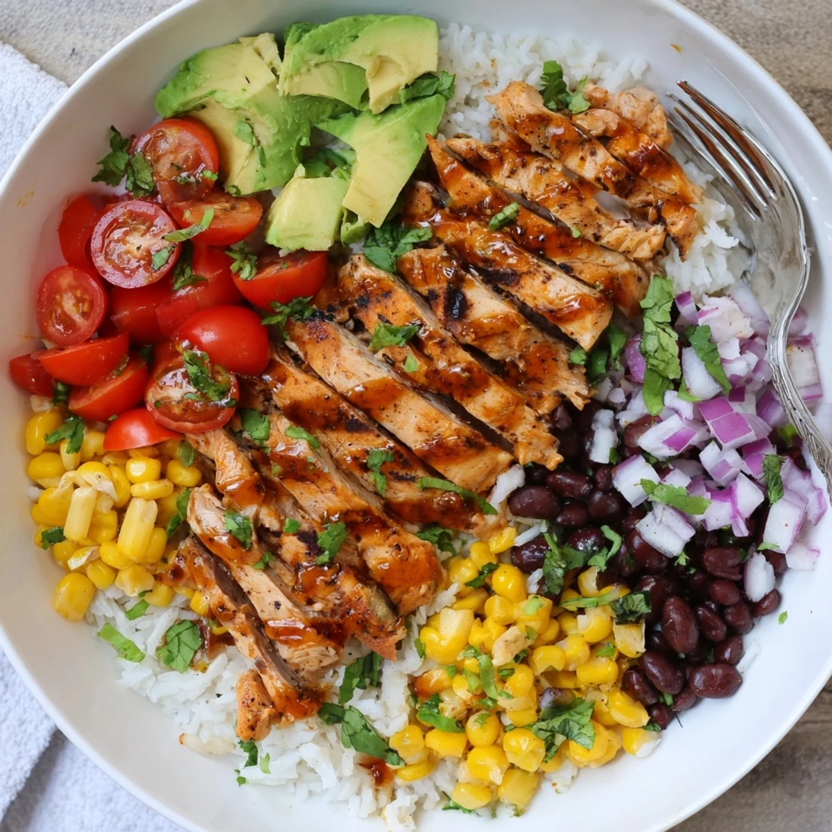 Honey Chipotle Chicken Rice Bowls topped with creamy avocado and vibrant cilantro garnish.  