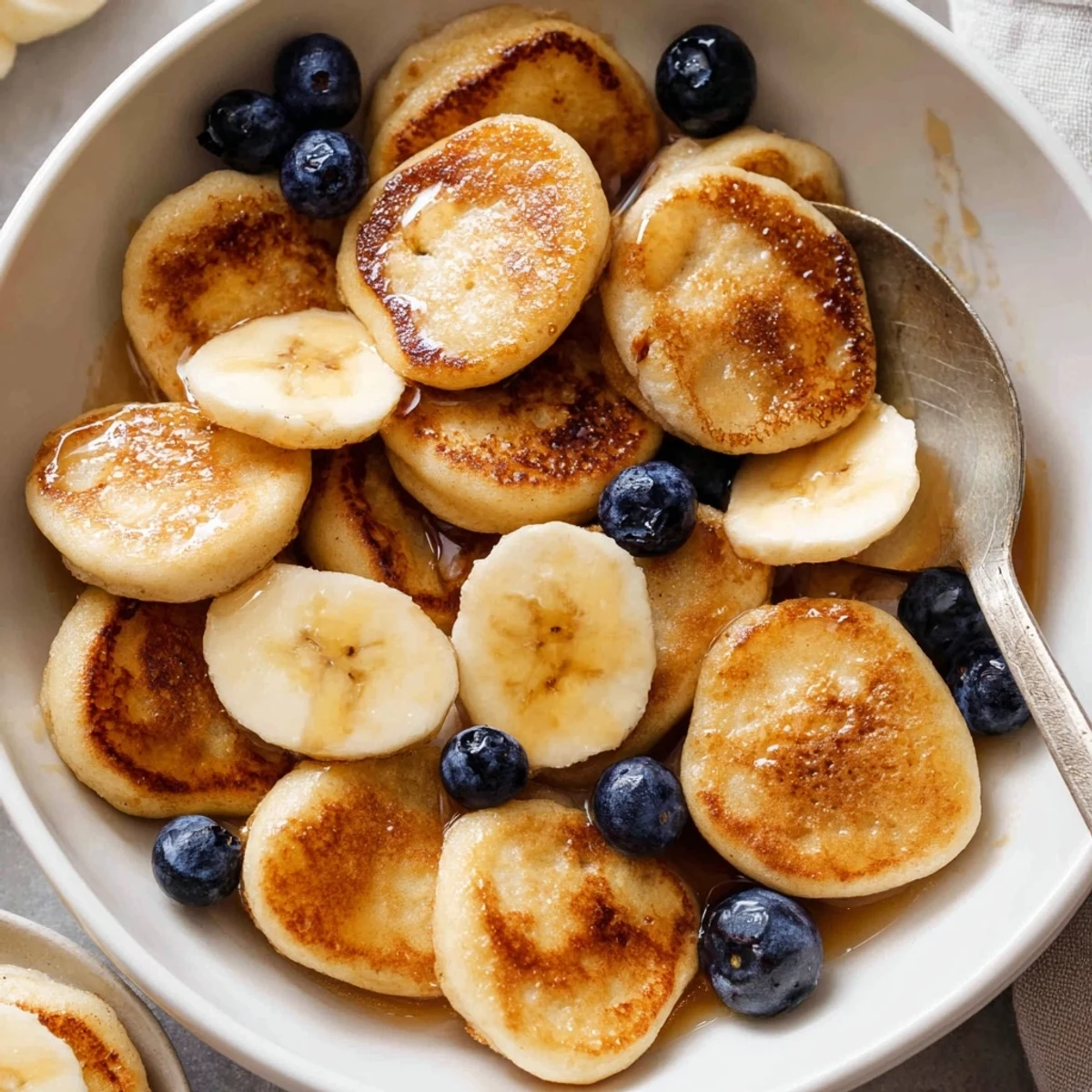 Adorable mini pancake cereal, golden and fluffy, perfect for a delightful breakfast bowl.  