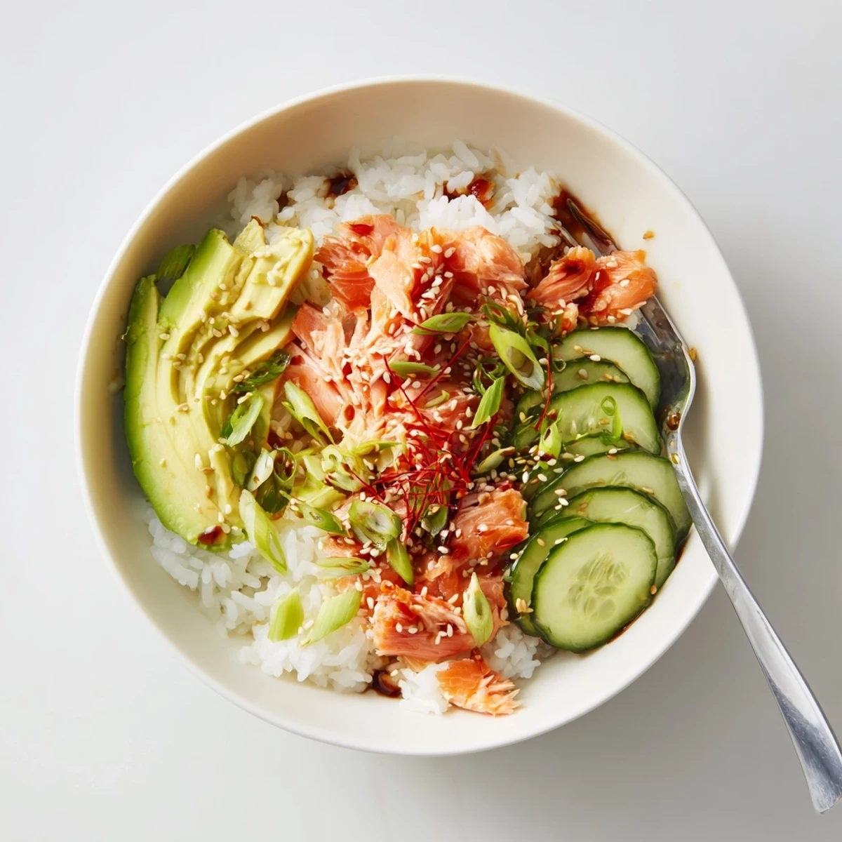 Enjoy a colorful Leftover Salmon & Rice Bowl, featuring fresh avocado and crunchy cucumber.