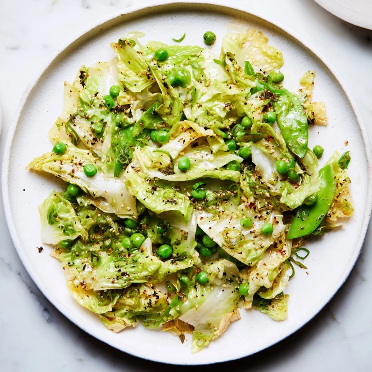 Vibrant Cabbage Stir-Fry with tender green peas and aromatics, perfect for a quick dinner side.