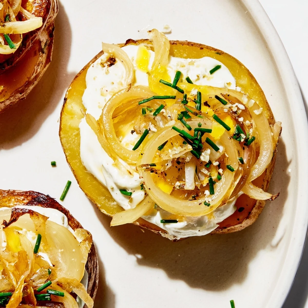 Golden French Onion Potato Bites, crispy potato rounds topped with caramelized onions ready to eat.