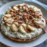 Sliced bananas and chia seeds garnish this warm High-Protein Breakfast Pizza Bowl, served in a ceramic dish for a cozy morning meal. 