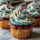 Vibrant swirled frosting on Star-Spangled Banner Cupcakes, topped with an American flag.