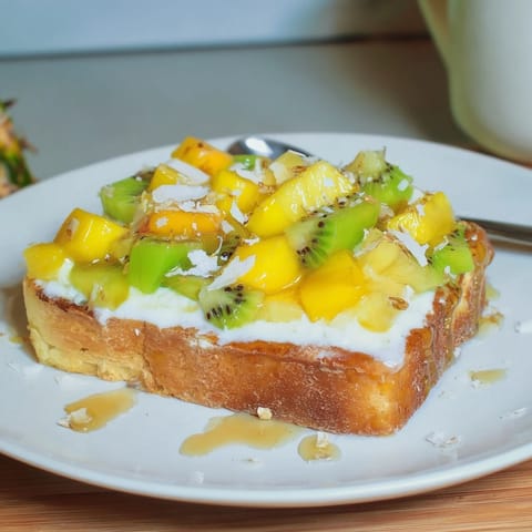 Delicious Yogurt-Custard Toast featuring coconut and exotic fruits, perfect for brunch delights.  