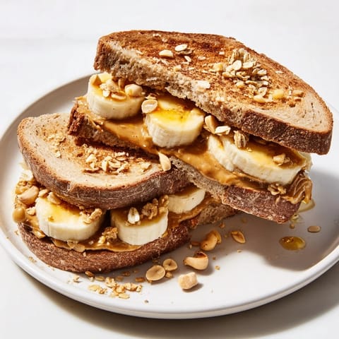 A close-up of a loaded Peanut Butter & Banana Sandwich upgrade with perfect banana slices and crunchy toppings.