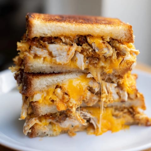 A close-up of a perfectly grilled Spicy Crispy Chicken Sandwich Grilled Cheese, ready to be sliced, inviting you to enjoy!