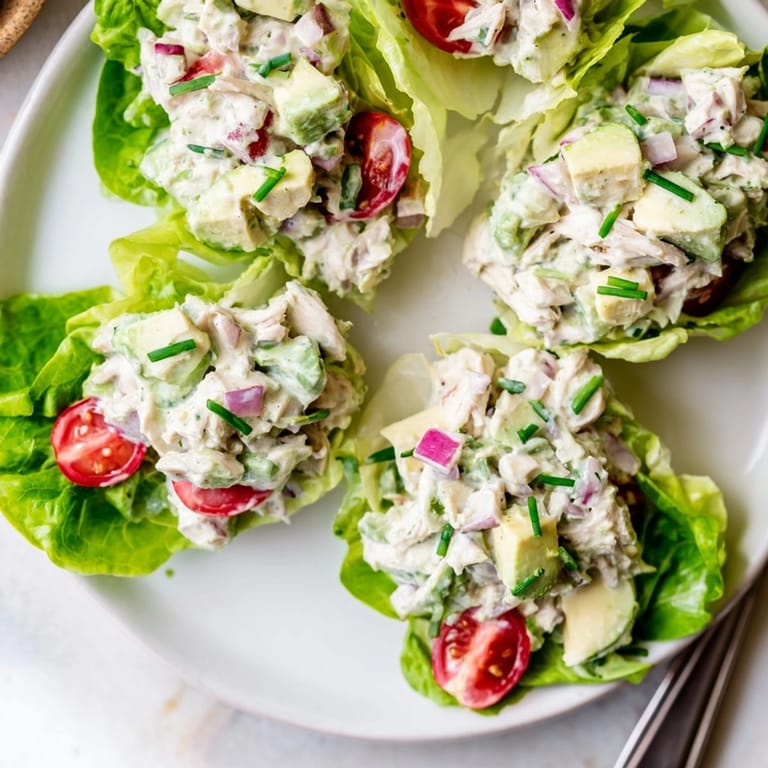 Close-up of avocado ranch chicken salad cups; creamy, savory chicken salad nestled in lettuce.
