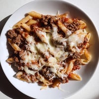 Golden, bubbly Cheesy Beef & Penne Bake with melted cheese and a savory meat sauce.